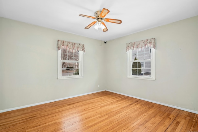 unfurnished room with ceiling fan, light wood-style flooring, and baseboards