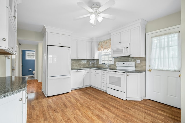 kitchen with light wood-type flooring, white appliances, white cabinetry, and dark stone counters