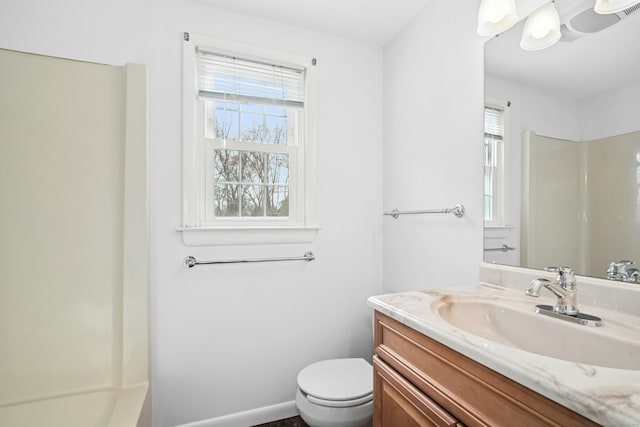 bathroom with toilet, a wealth of natural light, and vanity