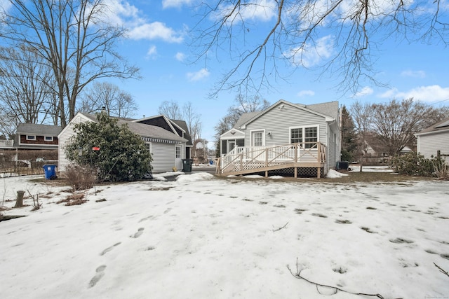 snow covered back of property featuring a deck