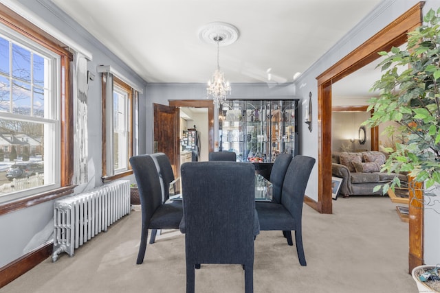 dining space featuring light colored carpet, baseboards, ornamental molding, radiator heating unit, and an inviting chandelier