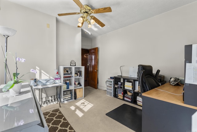 carpeted office space with ceiling fan