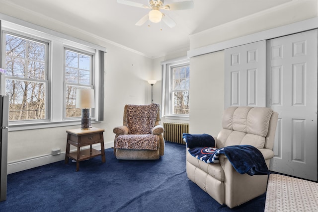 living area featuring crown molding, baseboards, carpet flooring, and radiator