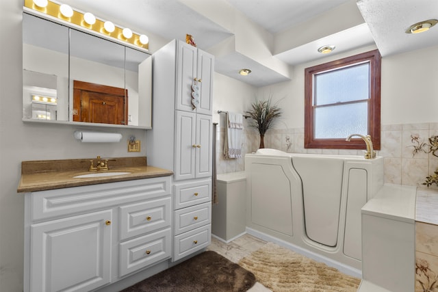 bathroom with a garden tub and vanity