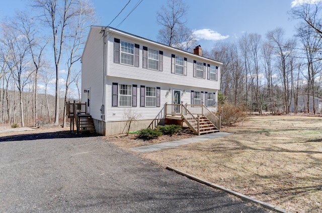 colonial-style house with driveway and a chimney