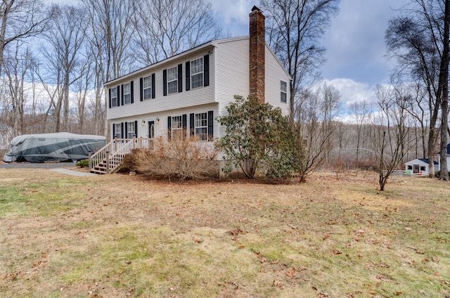 colonial-style house with a front lawn and a chimney