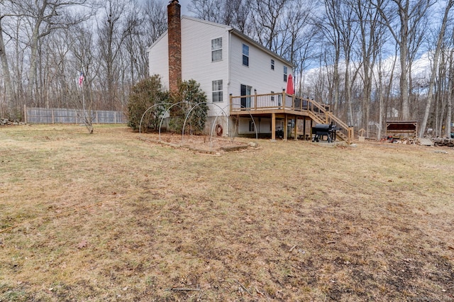 back of house with a wooden deck, a lawn, a chimney, and stairs