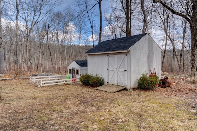 view of shed featuring a vegetable garden and a wooded view