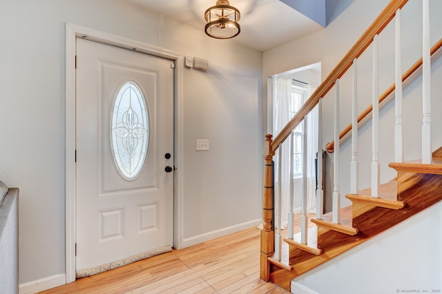 entryway featuring stairway, plenty of natural light, baseboards, and light wood-type flooring