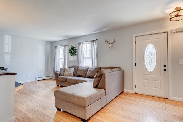 living area featuring light wood finished floors, baseboards, and a baseboard radiator