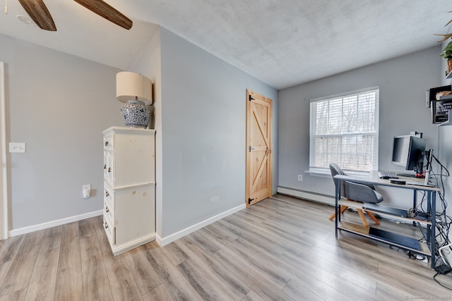 office area with baseboard heating, light wood-style flooring, baseboards, and ceiling fan