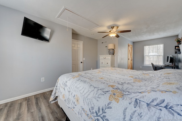 bedroom with dark wood-style floors, ceiling fan, attic access, and baseboards