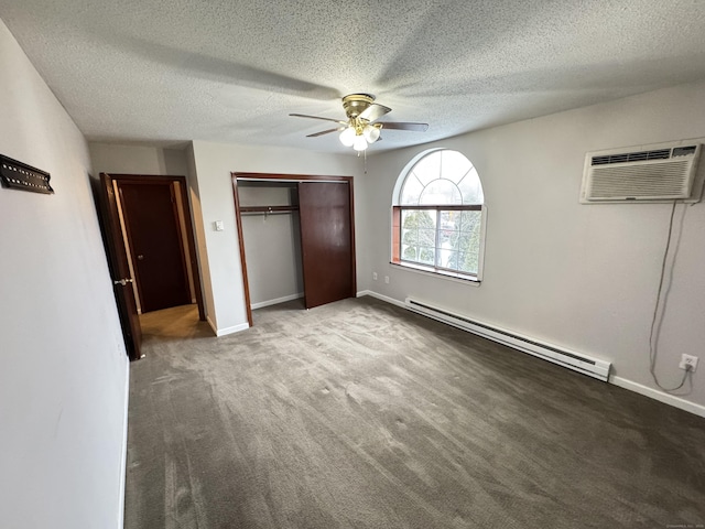 unfurnished bedroom with a baseboard radiator, a wall unit AC, baseboards, a closet, and carpet