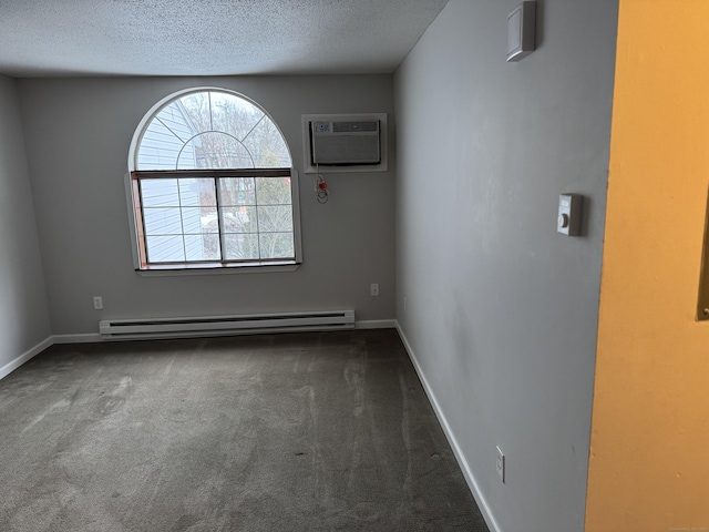 empty room with a textured ceiling, baseboards, baseboard heating, a wall mounted AC, and dark colored carpet