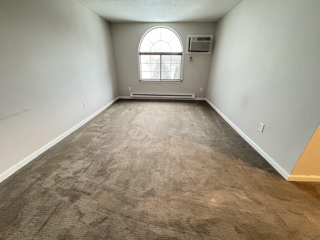 carpeted spare room featuring a wall unit AC, baseboards, baseboard heating, and a textured ceiling