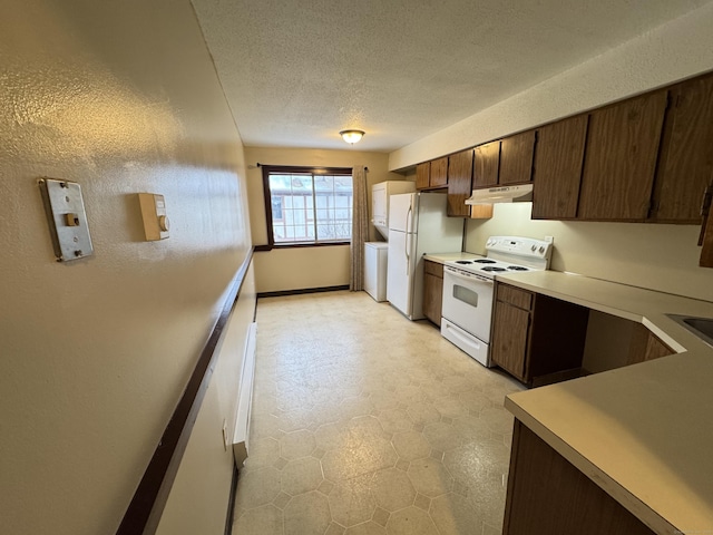 kitchen with white appliances, under cabinet range hood, light countertops, and a textured ceiling