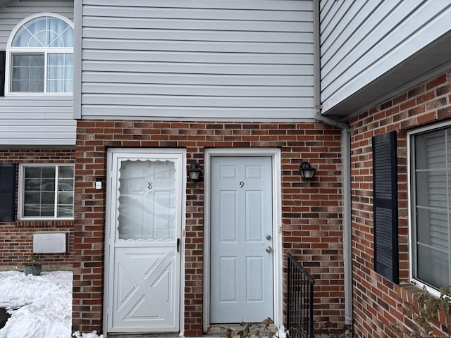 entrance to property featuring brick siding