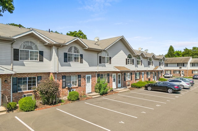 view of front of property with uncovered parking and brick siding