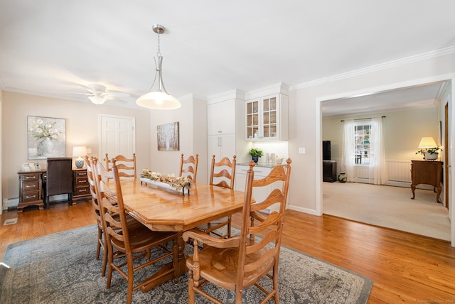 dining space with baseboards, ceiling fan, ornamental molding, baseboard heating, and light wood-style floors