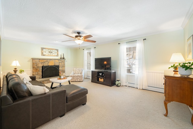 living area featuring a fireplace, baseboard heating, ornamental molding, wainscoting, and light carpet