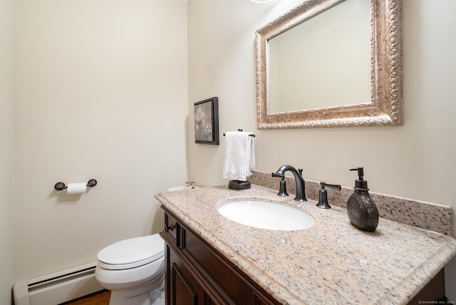 half bath featuring toilet, vanity, and baseboard heating