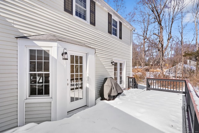 snow covered deck with french doors