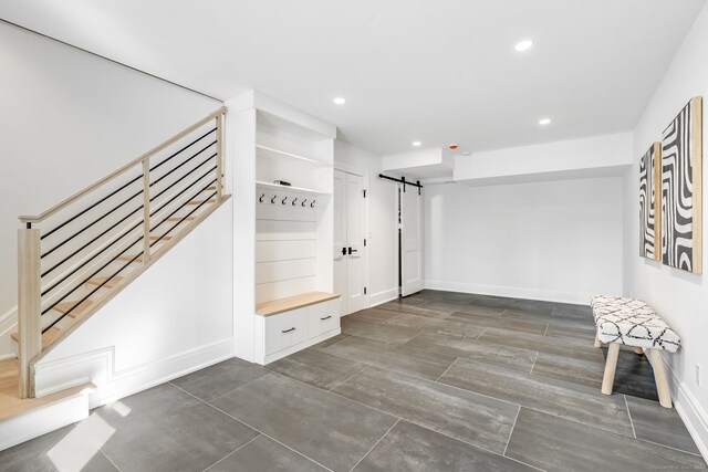 mudroom featuring baseboards, a barn door, and recessed lighting