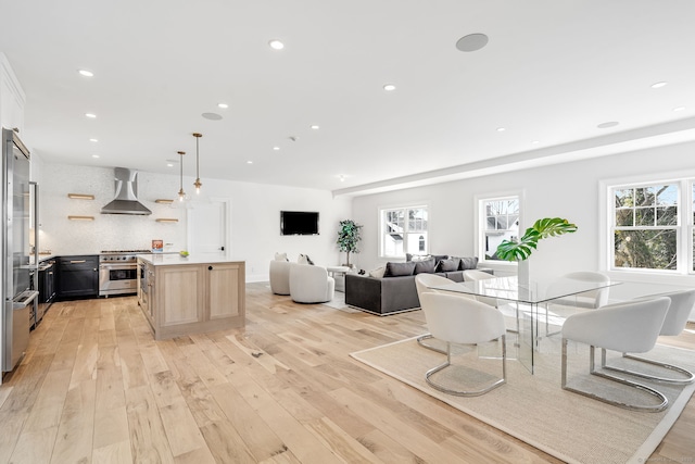 dining space featuring light wood-type flooring, plenty of natural light, and recessed lighting
