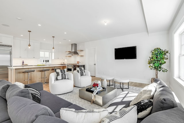 living room with recessed lighting, baseboards, and light wood-type flooring