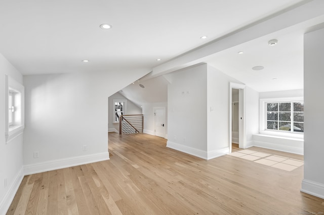 additional living space featuring lofted ceiling, light wood-style flooring, and baseboards