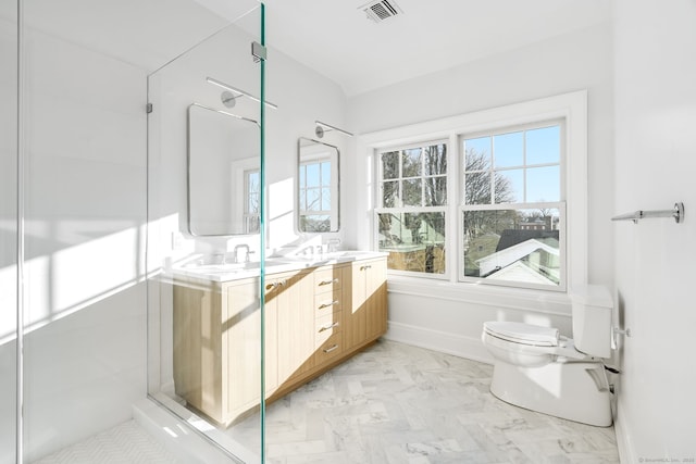 bathroom with double vanity, baseboards, visible vents, toilet, and a sink