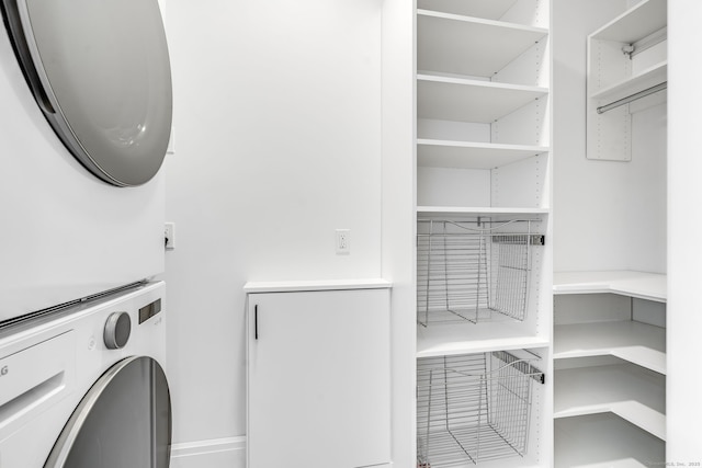washroom featuring stacked washer / drying machine and laundry area