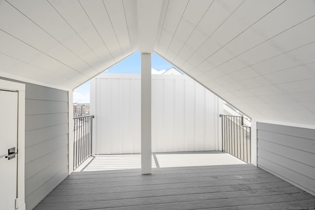 interior space with lofted ceiling, wood finished floors, and wooden walls