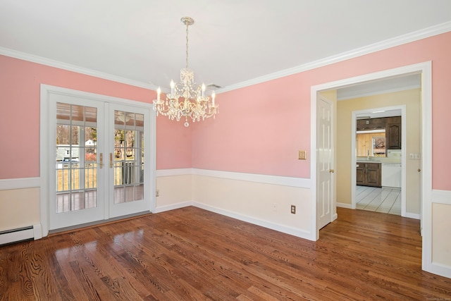 unfurnished dining area with french doors, crown molding, baseboard heating, wood finished floors, and baseboards