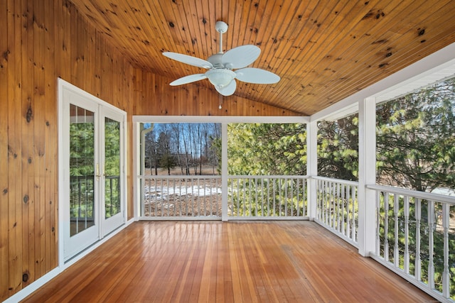 unfurnished sunroom with lofted ceiling, wooden ceiling, and a ceiling fan