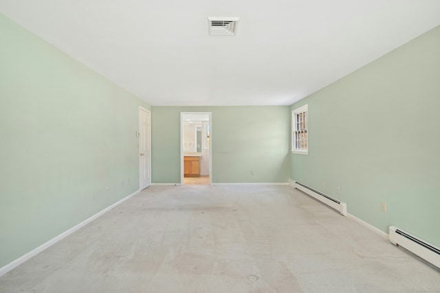 spare room featuring visible vents, a baseboard heating unit, and baseboards