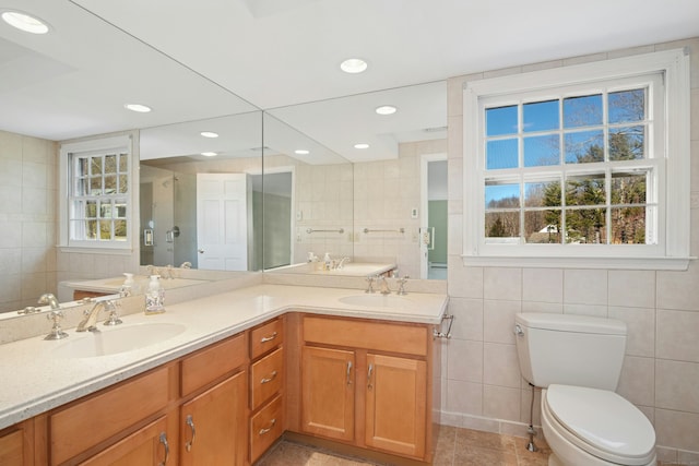 bathroom with a stall shower, a sink, tile walls, and toilet