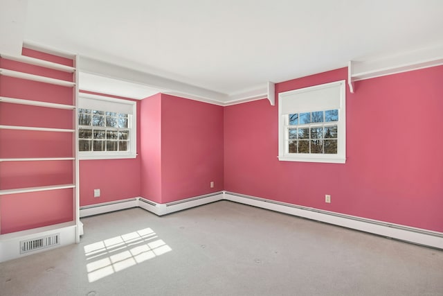 carpeted empty room with visible vents and baseboard heating