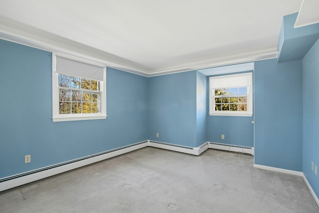 carpeted spare room with a baseboard heating unit and baseboards