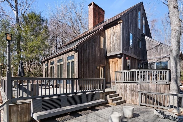 rear view of property featuring a deck and a chimney