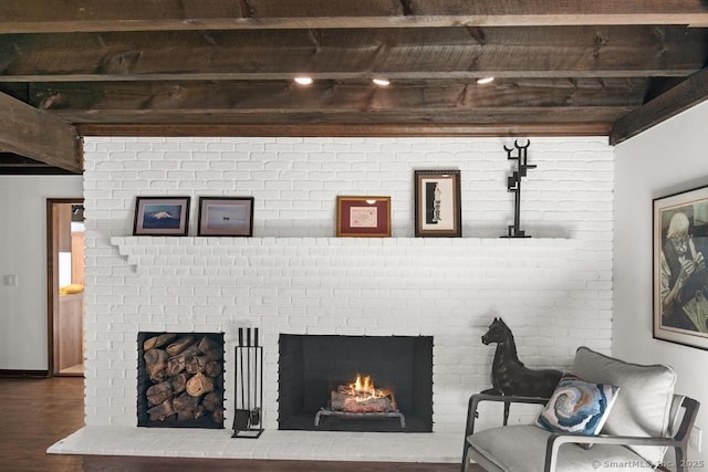 interior space featuring a fireplace, beamed ceiling, and wood finished floors