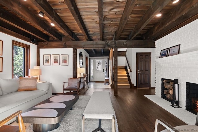 living room featuring wooden ceiling, a fireplace, wood finished floors, stairway, and beamed ceiling