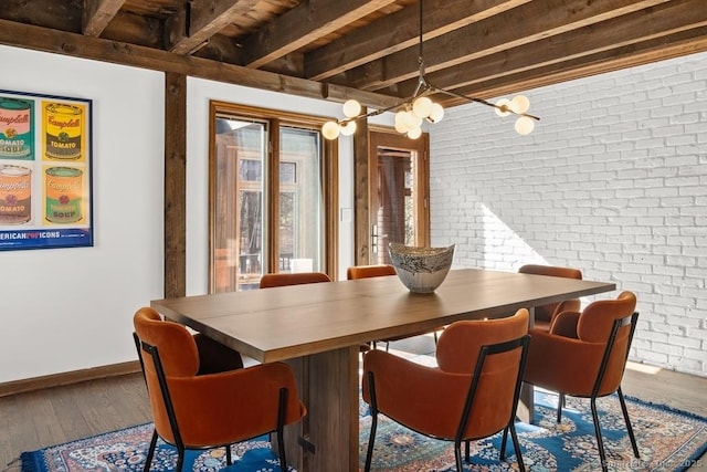 dining room with brick wall, beamed ceiling, wood finished floors, and baseboards