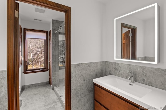 full bathroom with visible vents, a shower stall, and vanity