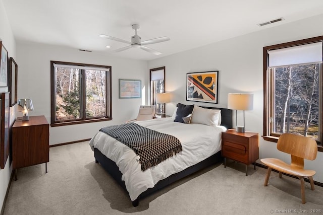 bedroom with a ceiling fan, visible vents, light carpet, and baseboards