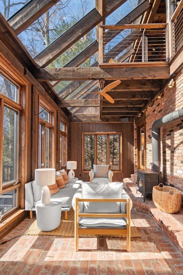 sunroom / solarium featuring a wood stove and a wealth of natural light