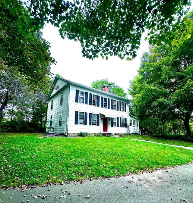 colonial home with a front lawn and a chimney