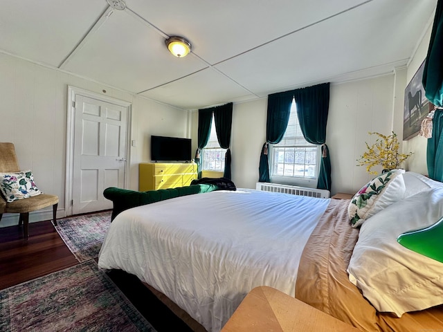 bedroom featuring radiator heating unit and dark wood-style flooring