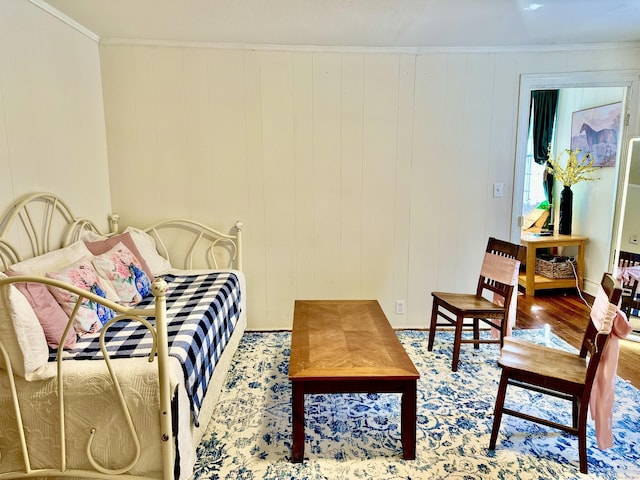 bedroom with ornamental molding and wood finished floors