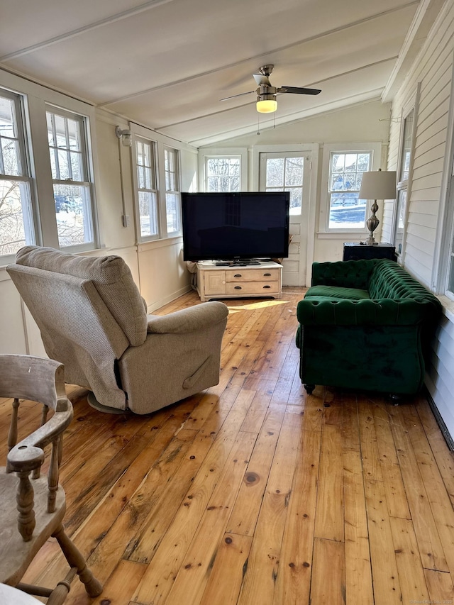 living area with vaulted ceiling with beams, light wood-style flooring, and ceiling fan